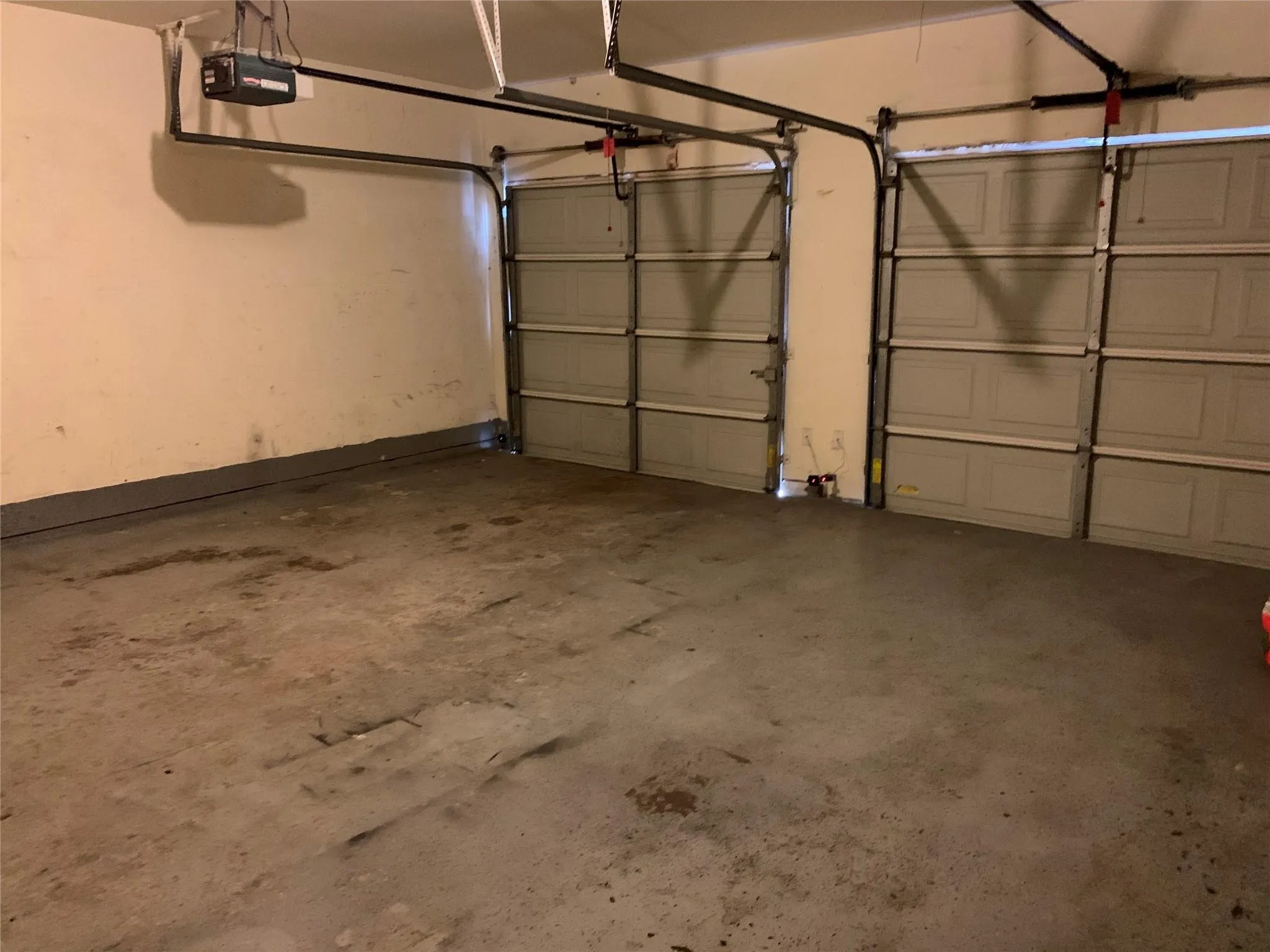 Two-car garage with concrete flooring and overhead garage door openers