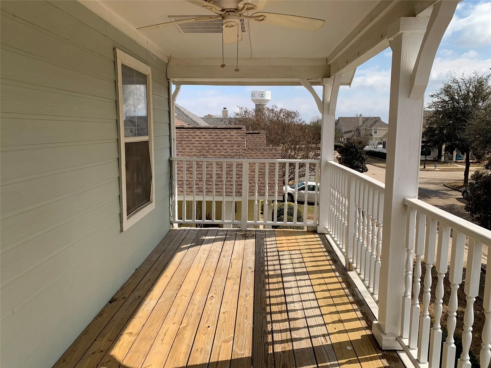 Covered porch featuring wood plank flooring and a ceiling fan