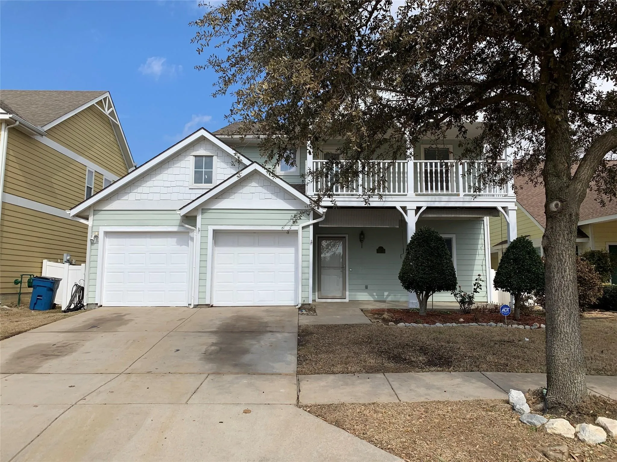 Two-story home featuring light green siding and white trim