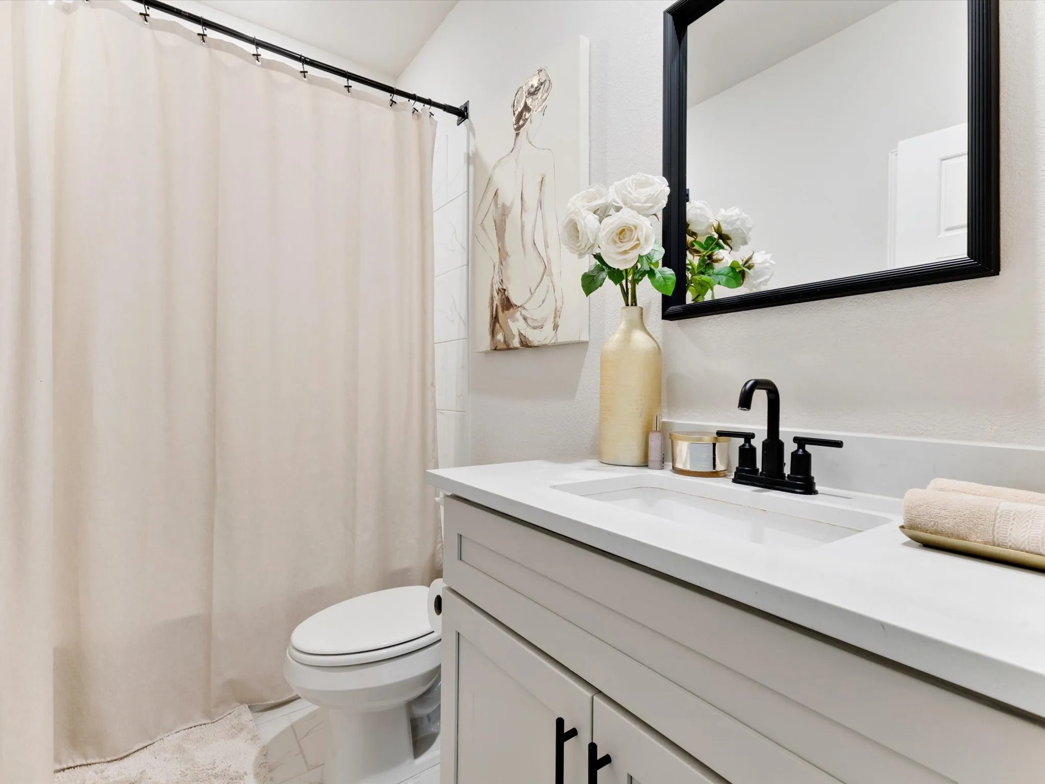 Bathroom featuring a white vanity with a rectangular integrated sink and a matte black faucet