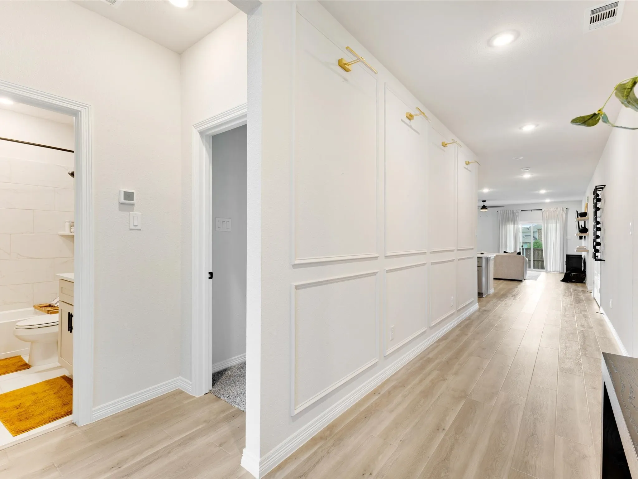 Entryway corridor featuring decorative wainscoting, recessed lighting, and wood-finish flooring