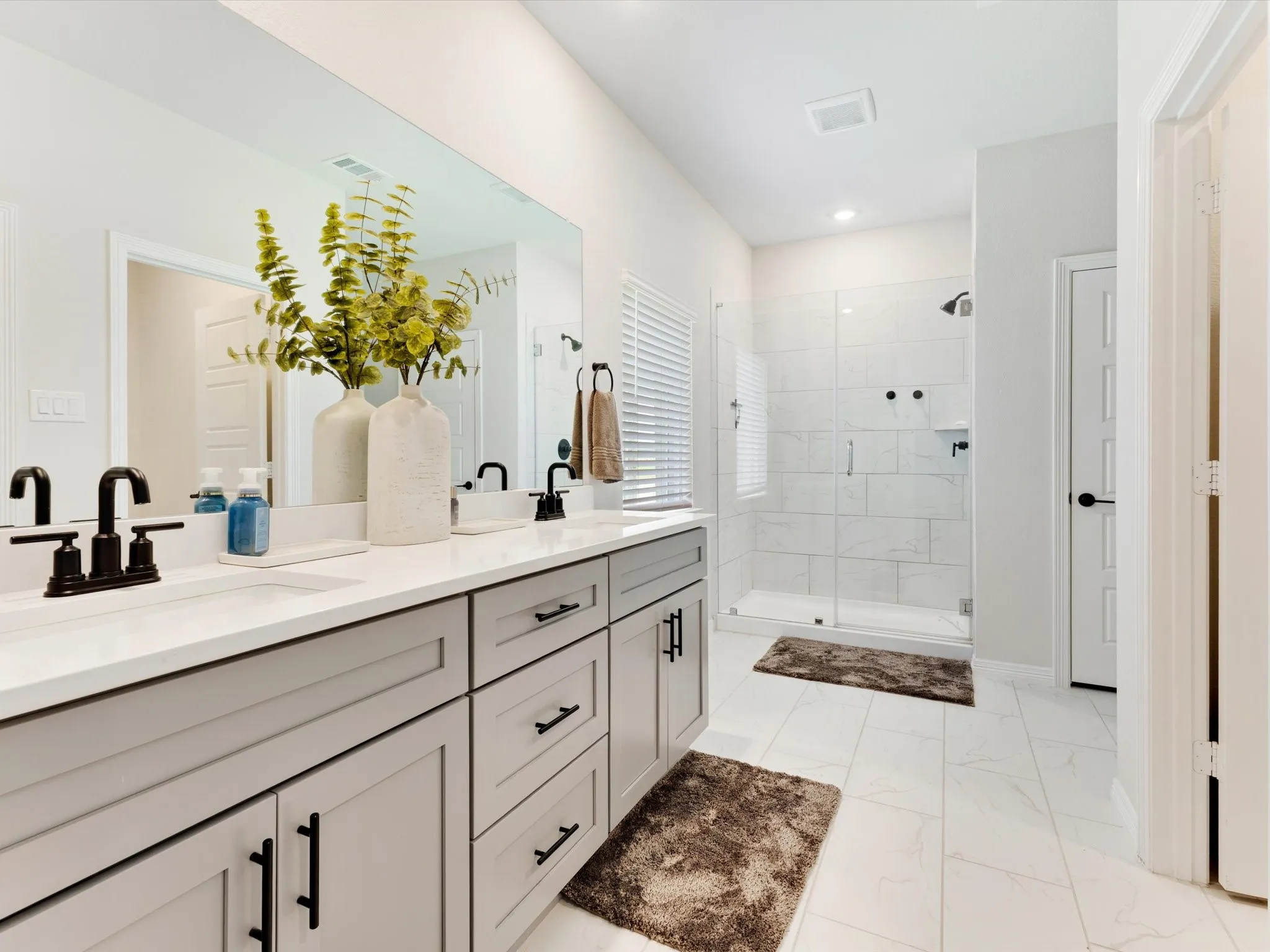 Double vanity with stone countertop, under-mount sinks, and matte black fixtures