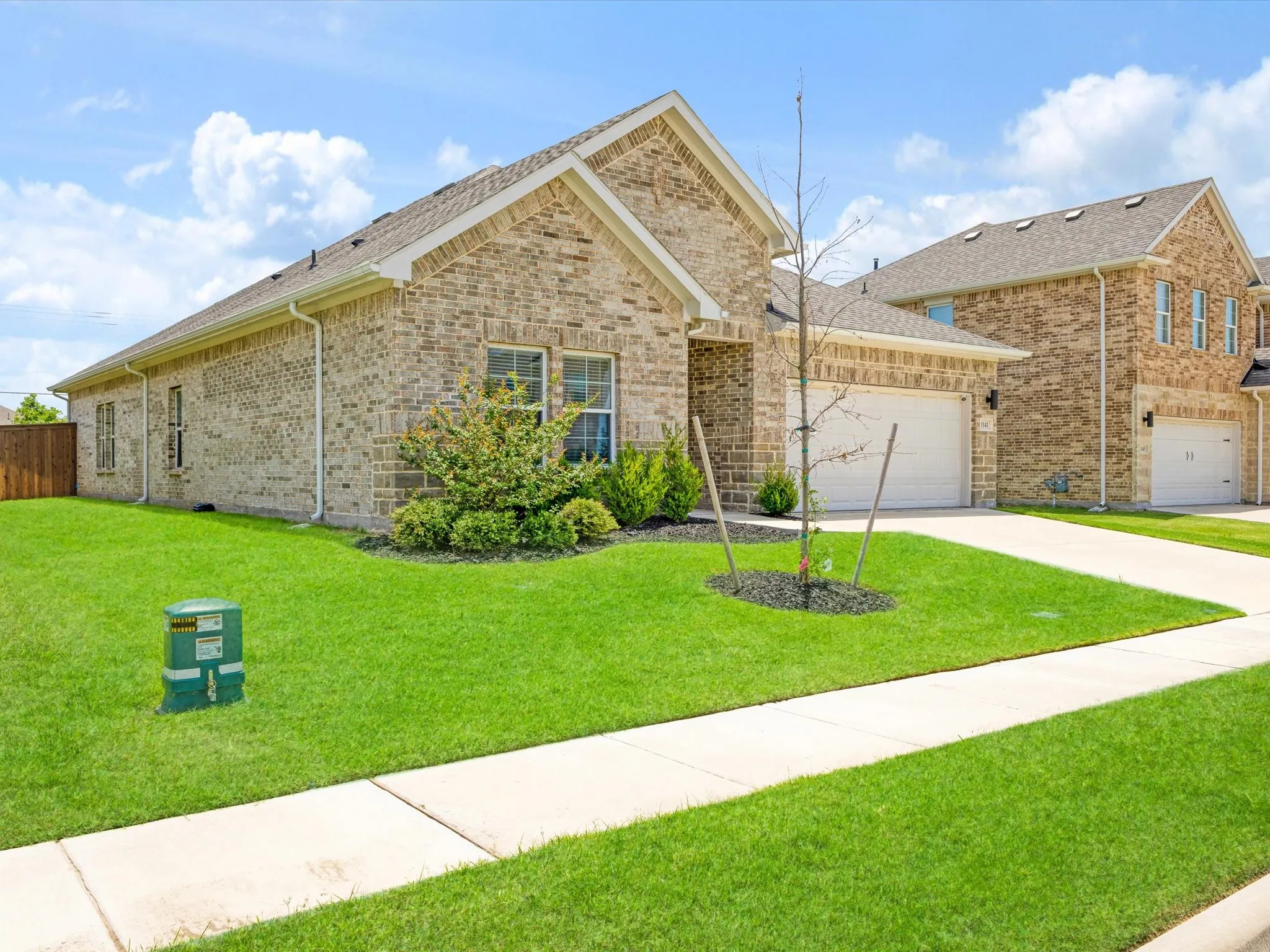Traditional-style home featuring a light brick facade and an attached two-car garage