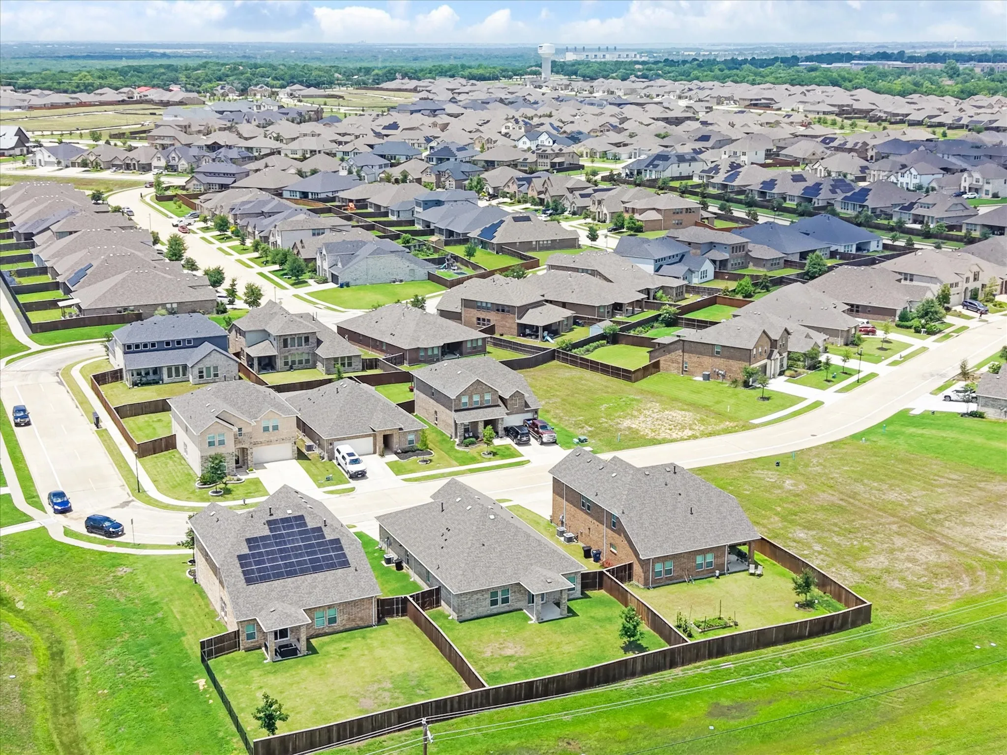 Expansive residential development featuring numerous single-family homes with diverse architectural styles, fenced backyards, and mature landscaping