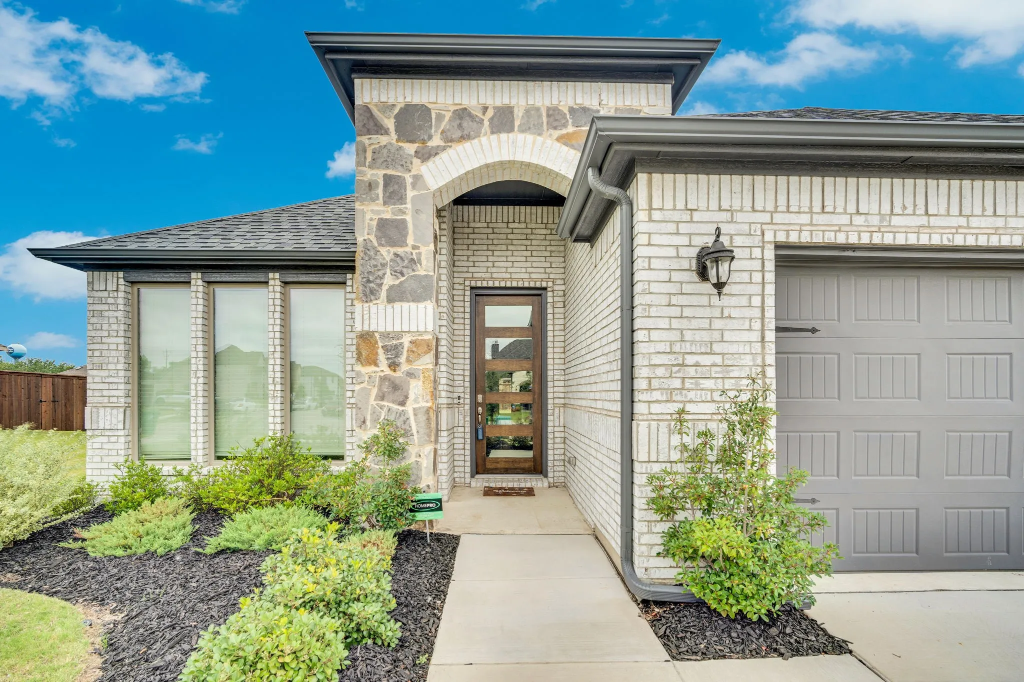 Glass front door and landscaped yard.