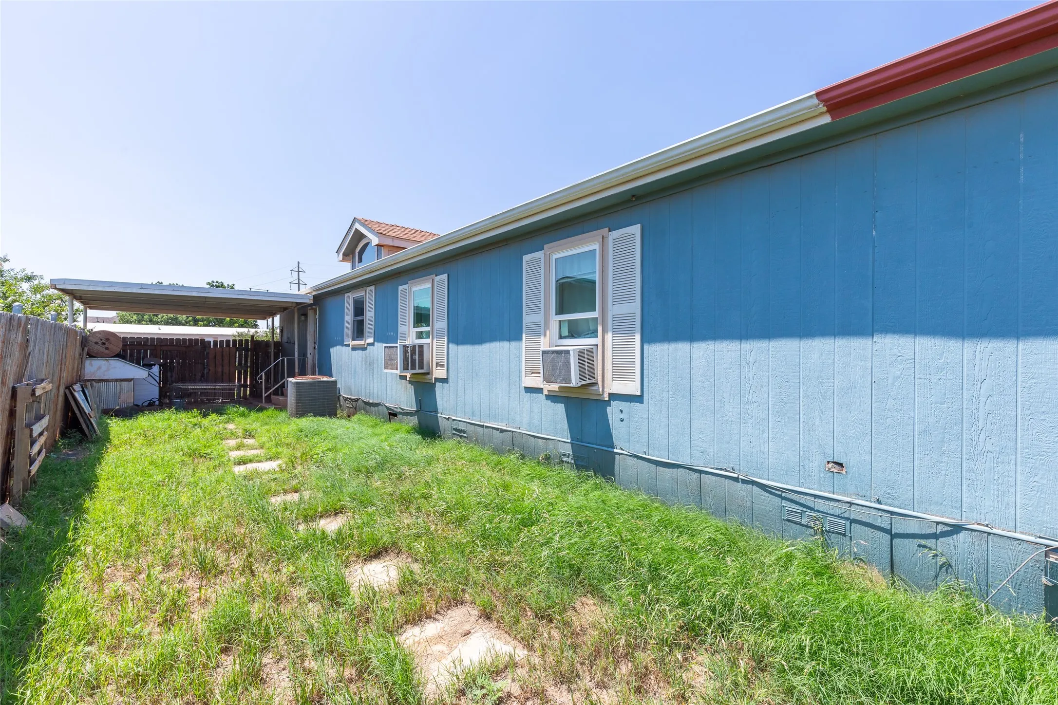 Exterior featuring blue siding and white window shutters