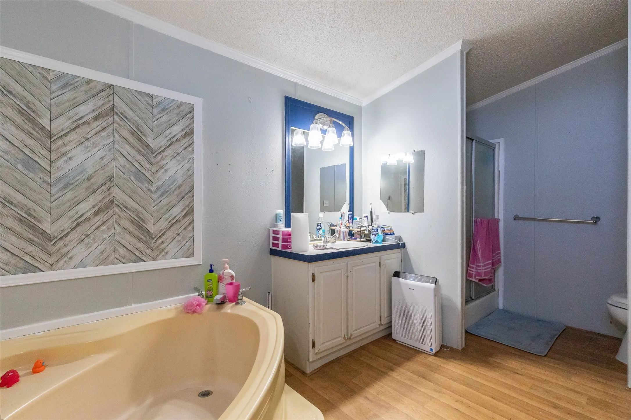 Spacious bathroom featuring a corner soaking tub, a vanity with dual mirrors, and a dedicated shower stall
