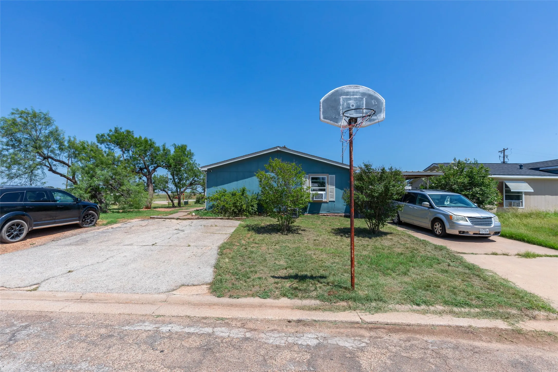 Single-story residence featuring a blue exterior and a concrete driveway