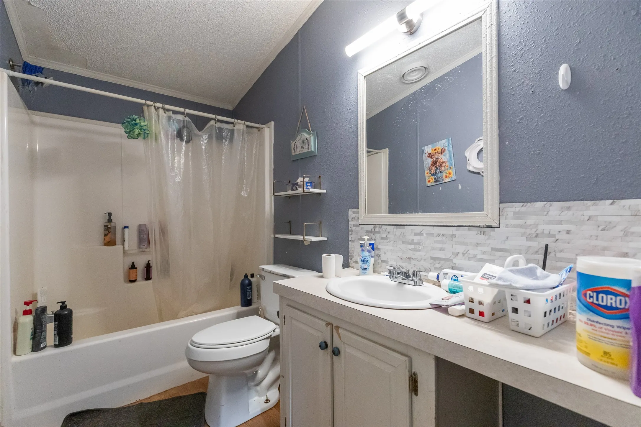 Bathroom featuring a tub/shower combination, white vanity with integrated sink, and framed mirror with overhead lighting