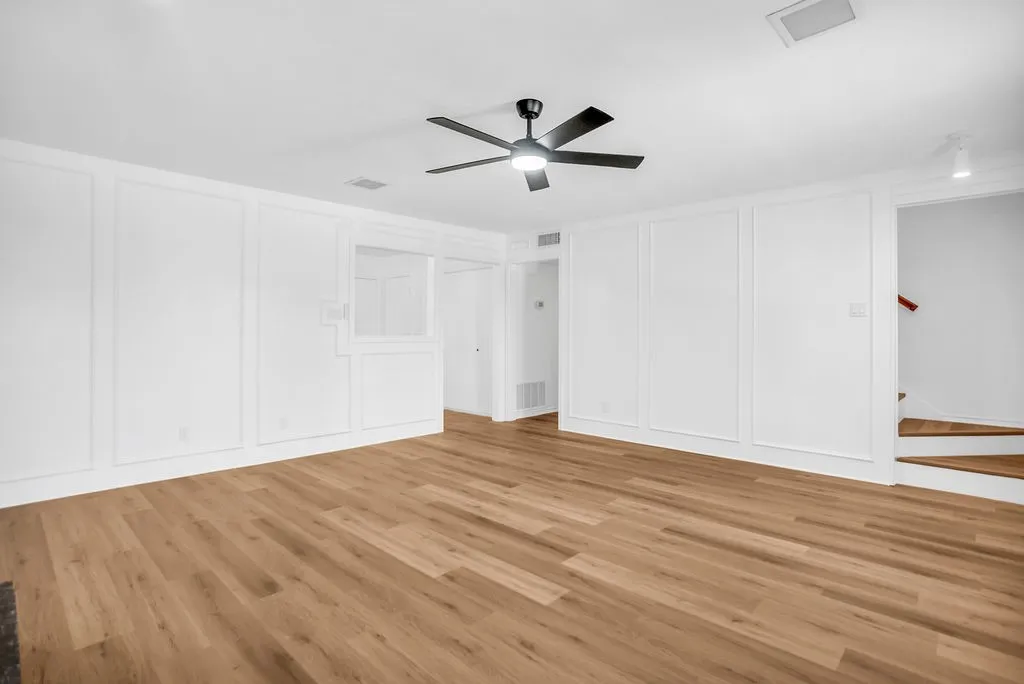 New Luxury Vinyl Plank floors throughout. Kitchen & dining entry far left. Hallway leads to bath and 2 bedrooms.  Stairwell entry on right.