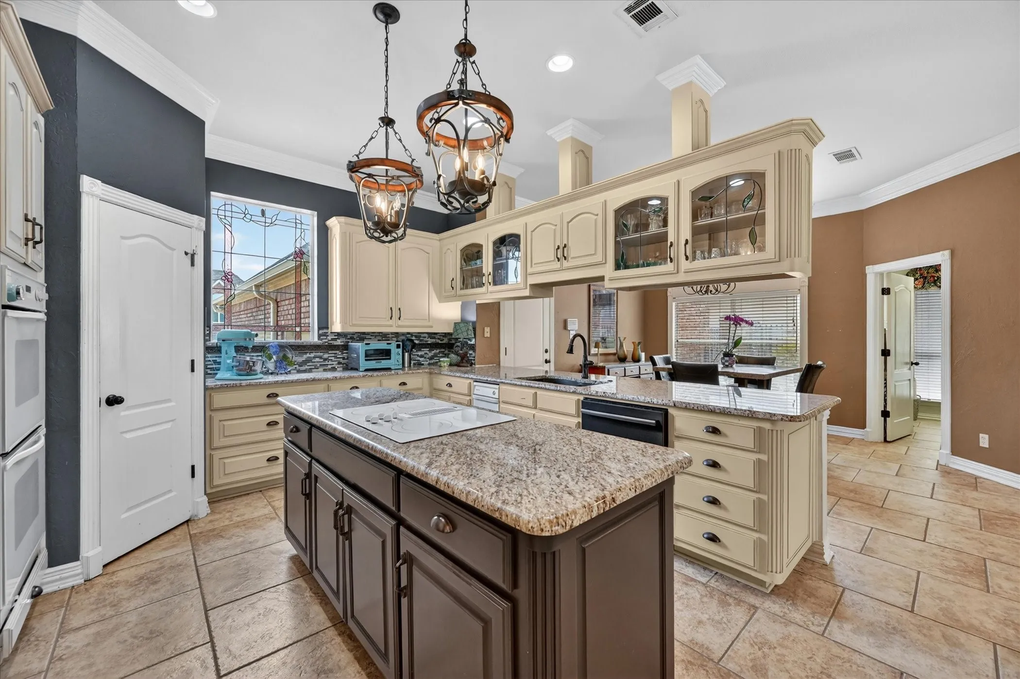 Central kitchen island with a built-in cooktop and granite-style countertop