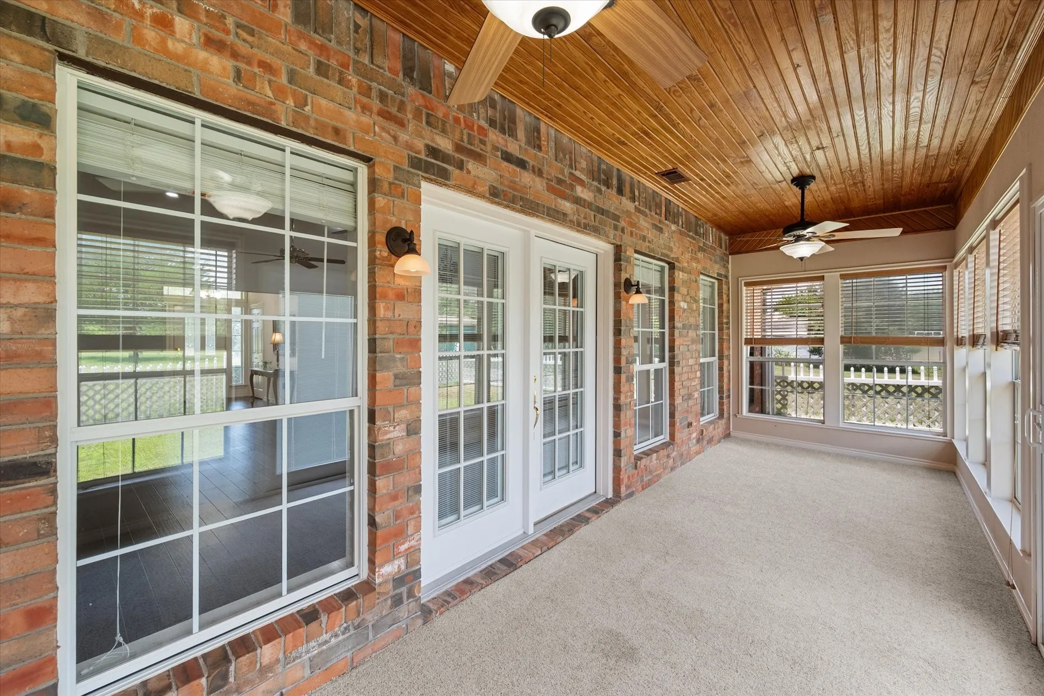 Sunroom near Corsicana with brick accents, ceiling fans, and bright windows for relaxing year-round.