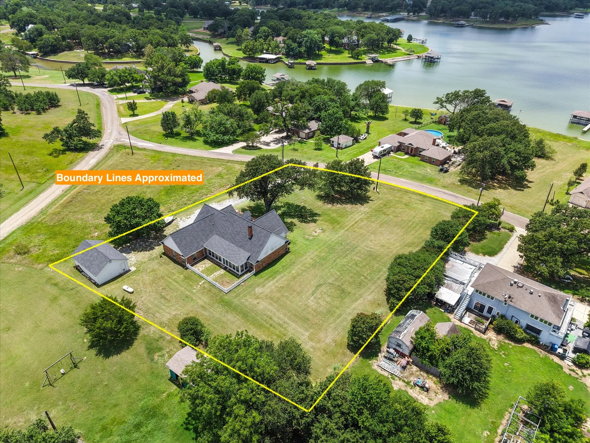 Aerial view near Corsicana showcasing nearby homes, open green space, and the lake-area neighborhood setting.