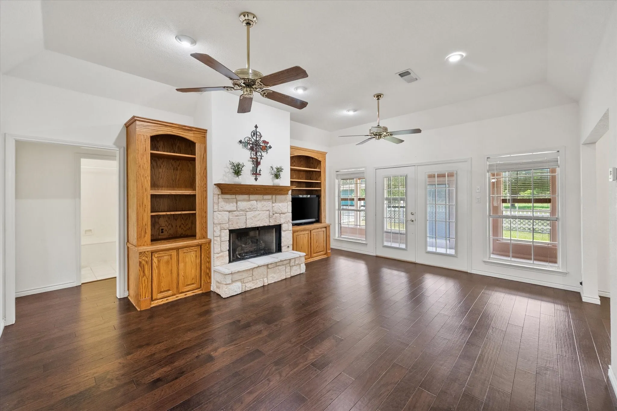 Large living area near Corsicana with fireplace, built-in shelving, and generous natural light throughout the room.