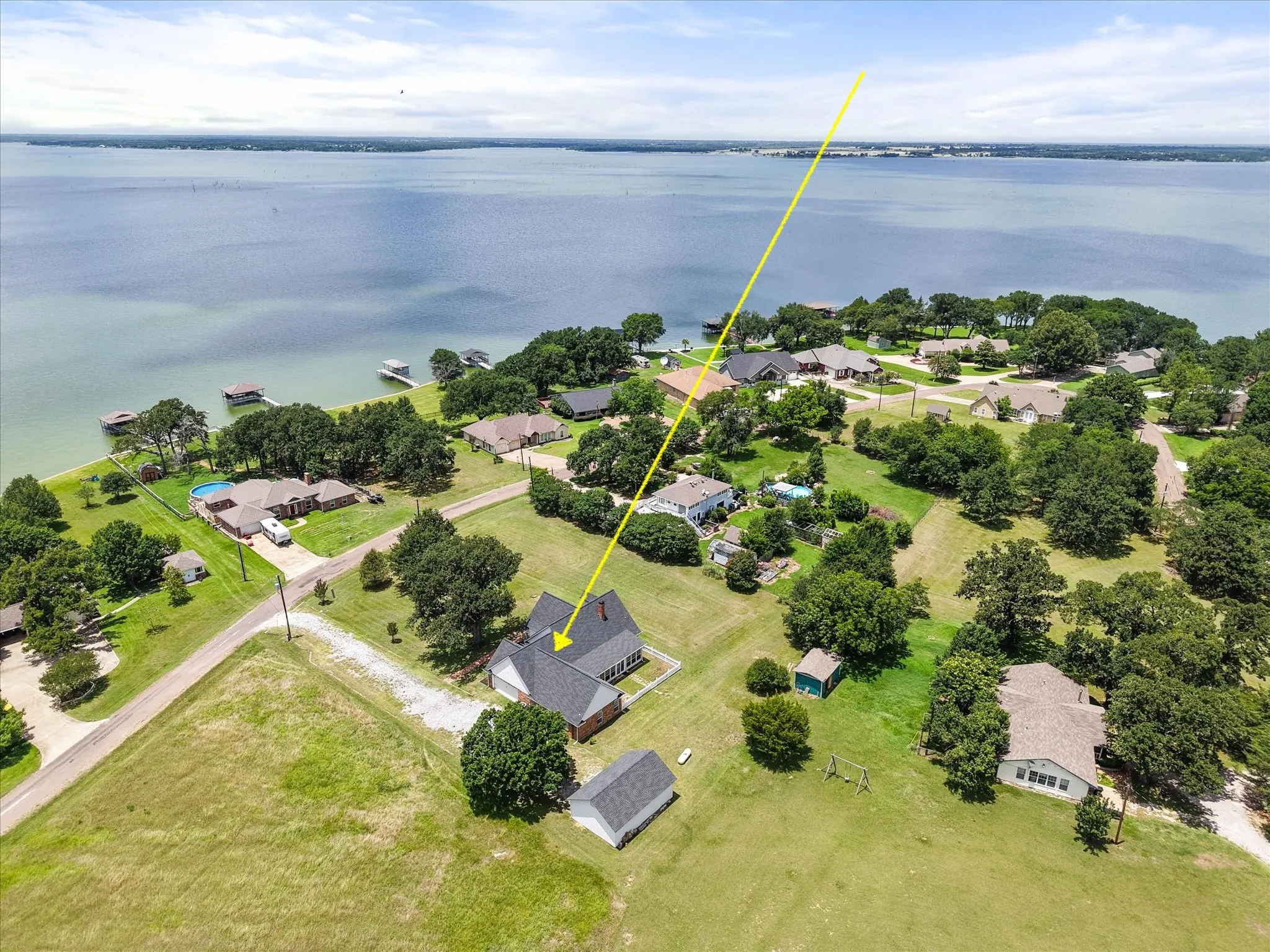Lake-area aerial near Dallas showing the home’s close proximity to surrounding shoreline and open water.