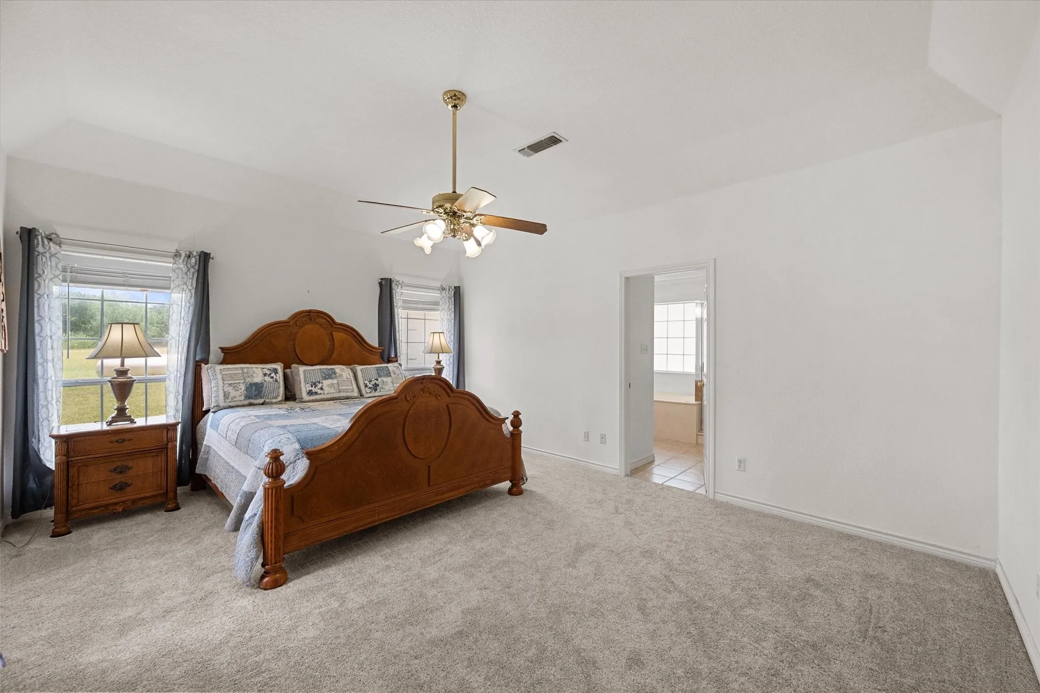 Primary bedroom near Richland Chambers Lake with soft carpet, natural light, and direct access to the ensuite bathroom.