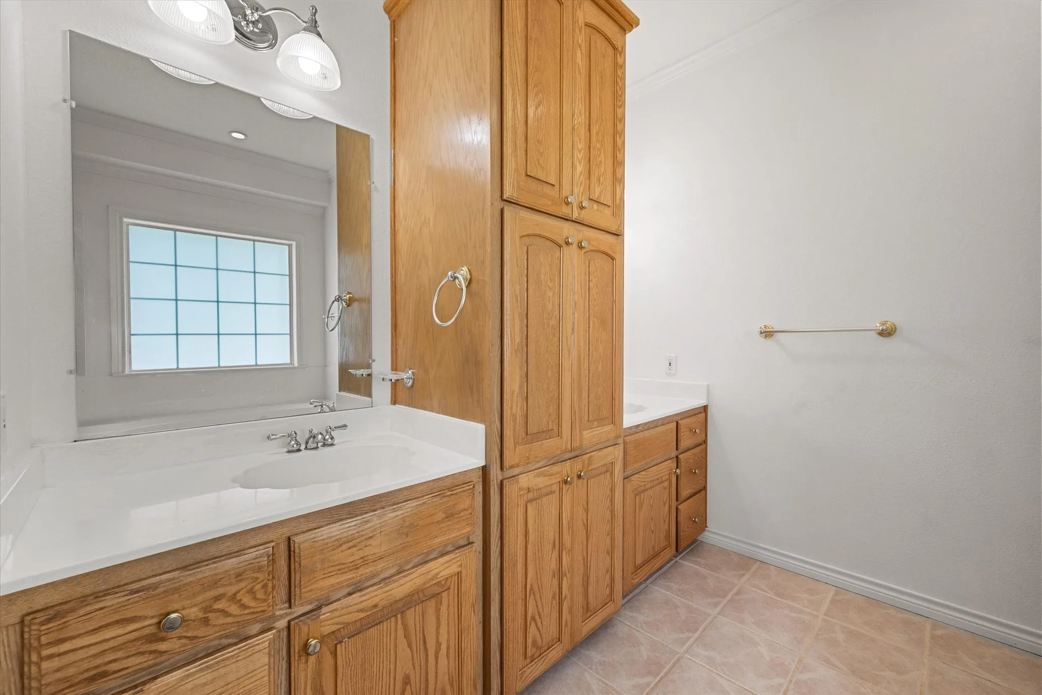 Primary bathroom in Streetman, TX featuring dual vanity areas, built-in storage, and a spacious layout.