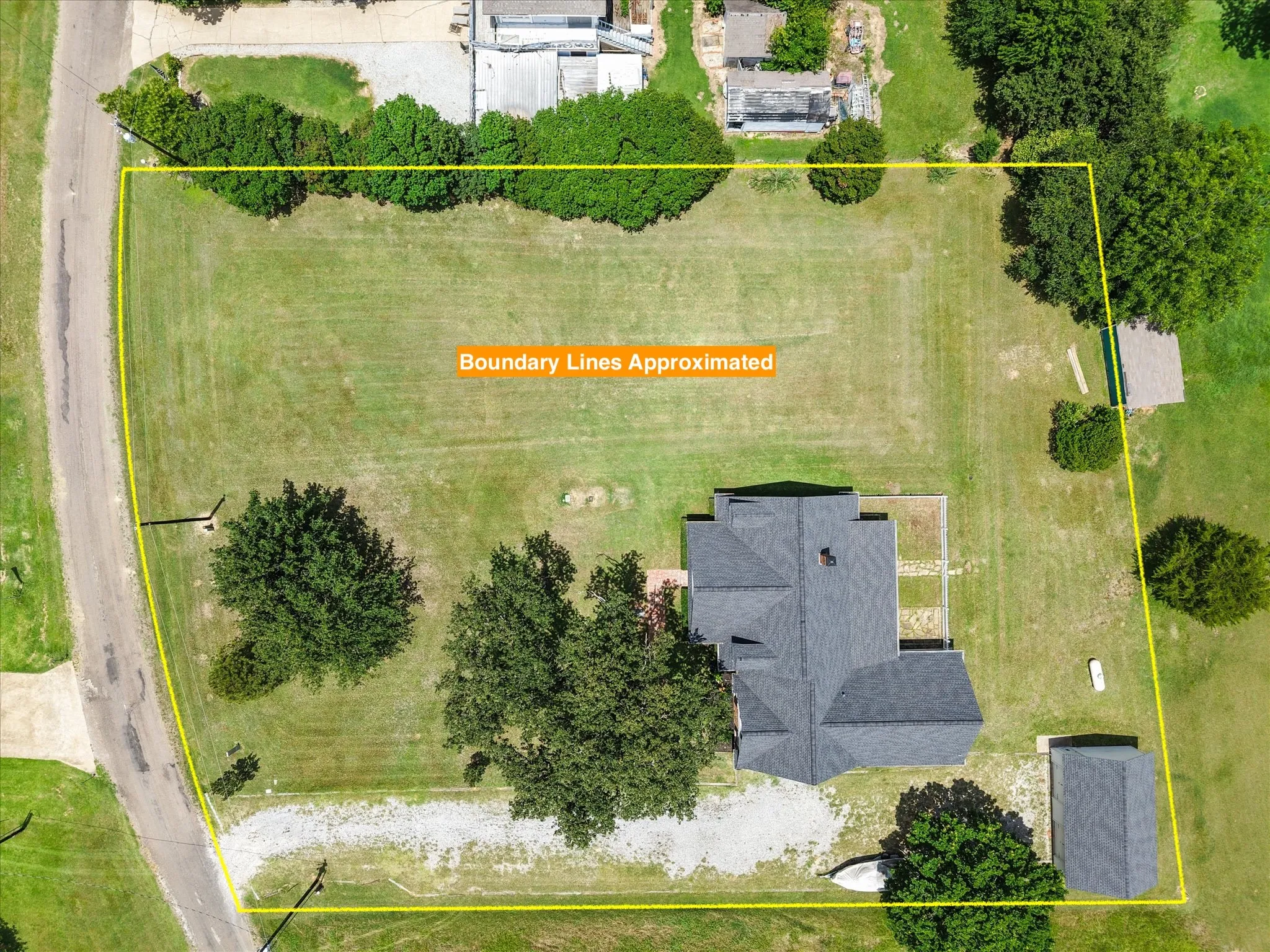 Aerial view near Dallas highlighting the 1-acre lot, home placement, driveway, and detached garage or storage building.