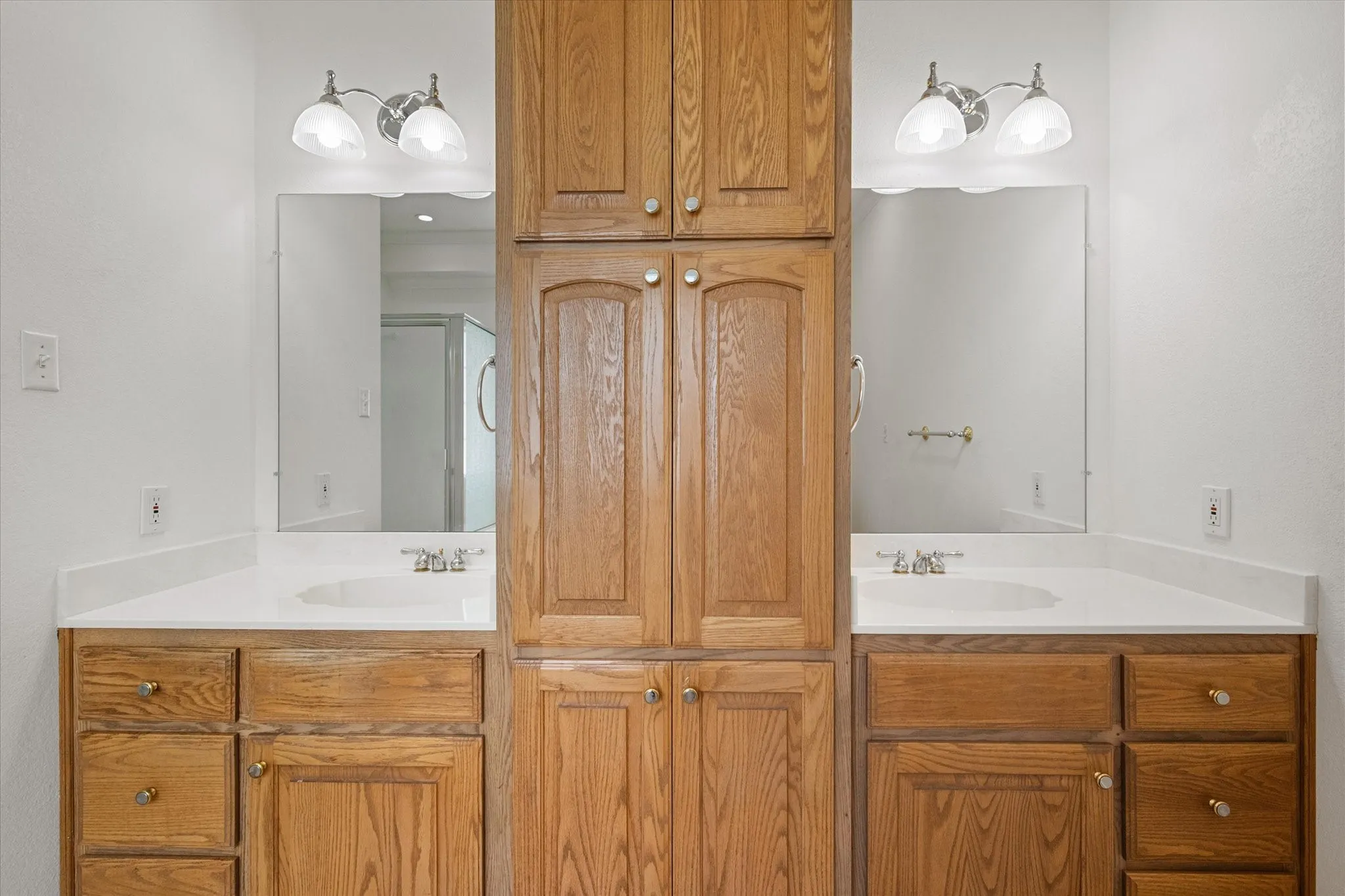 Primary bath near Corsicana with separate vanities, abundant cabinetry, and practical storage for everyday convenience.