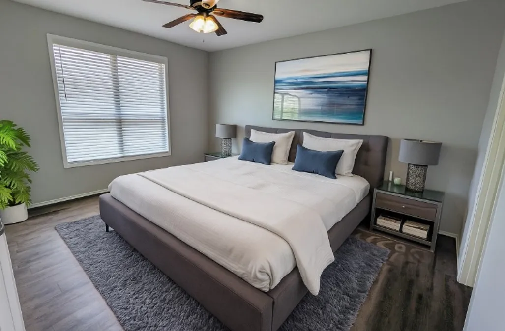 Spacious room featuring wood-finish flooring, a ceiling fan, and window with blinds