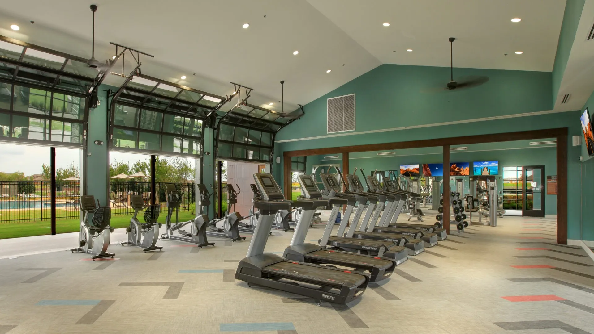 Fitness center with a vaulted ceiling, recessed lighting, and ceiling fans