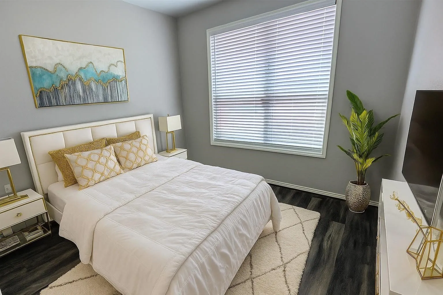 Spacious room featuring wood-finish flooring, a large window with blinds, and light gray wall paint