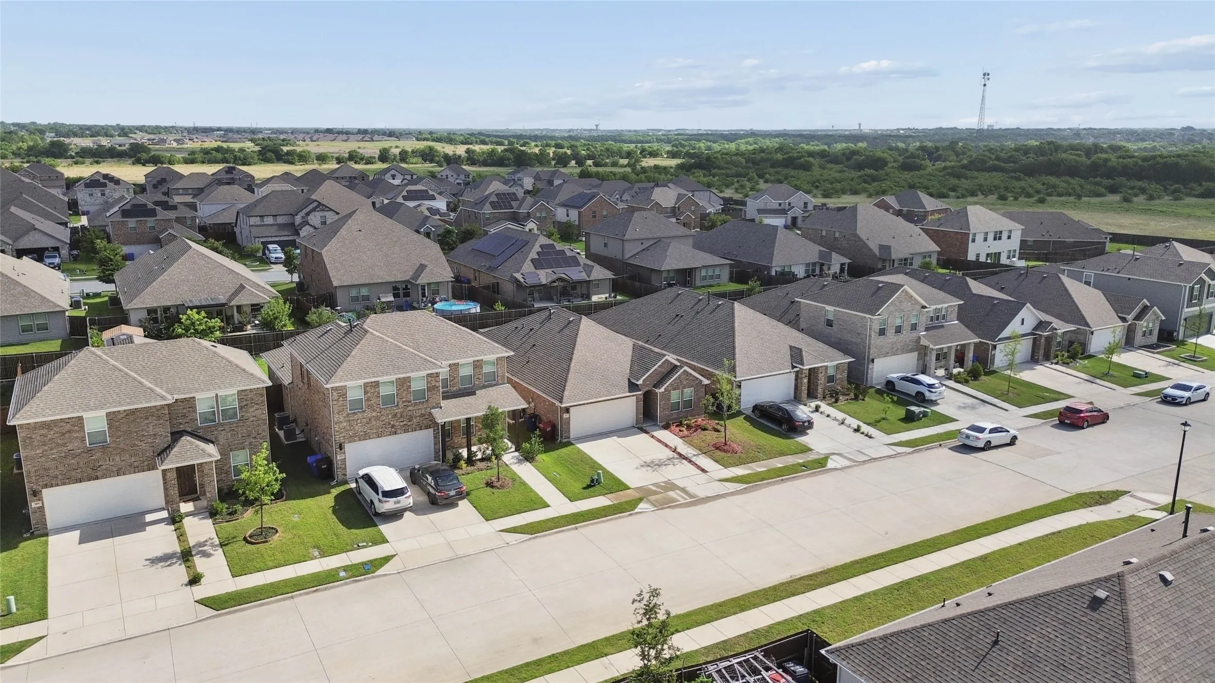 Residential neighborhood featuring a consistent architectural style, brick and siding exteriors, attached garages, and paved driveways