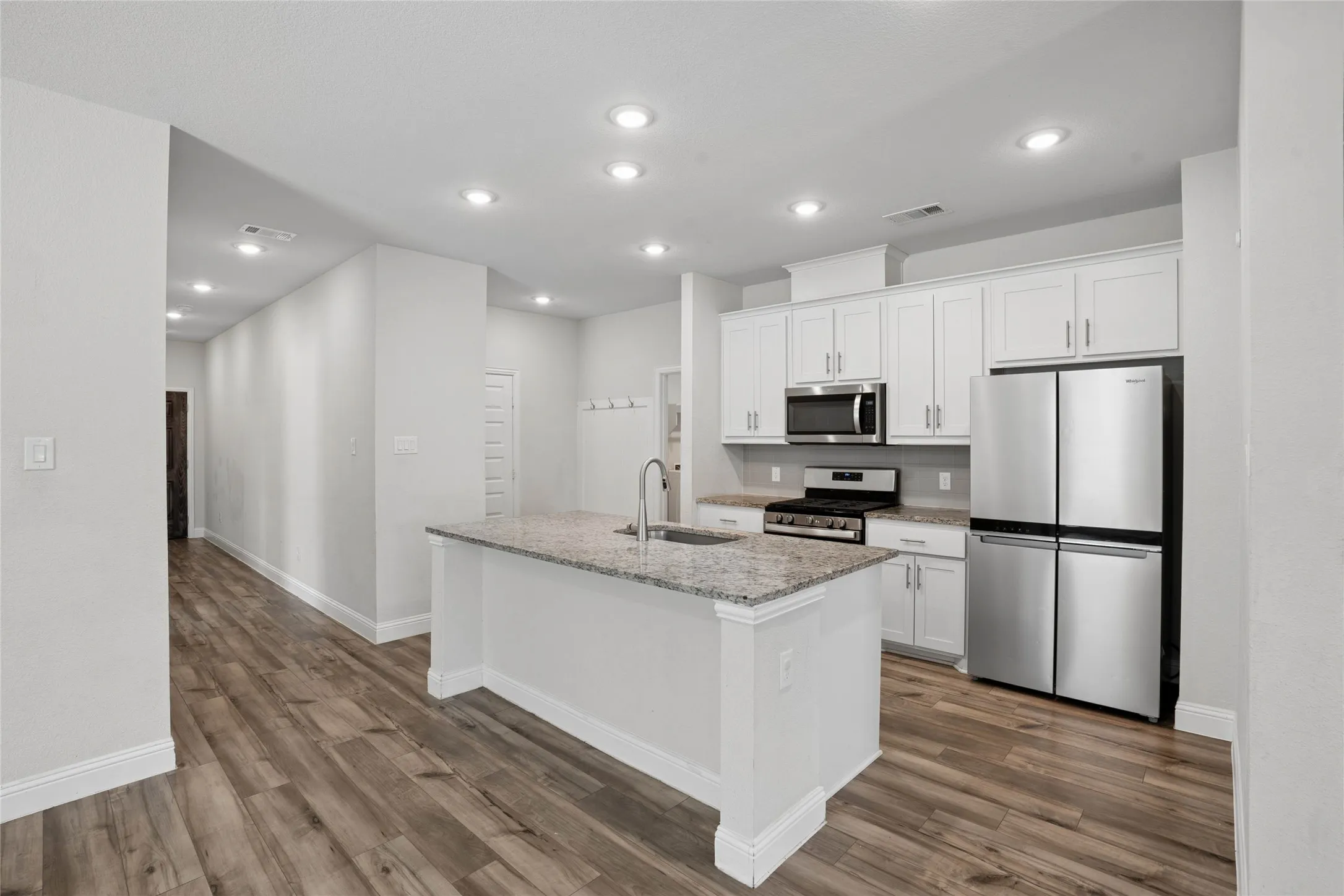 Kitchen with white shaker cabinetry, stainless steel appliances, and granite countertops