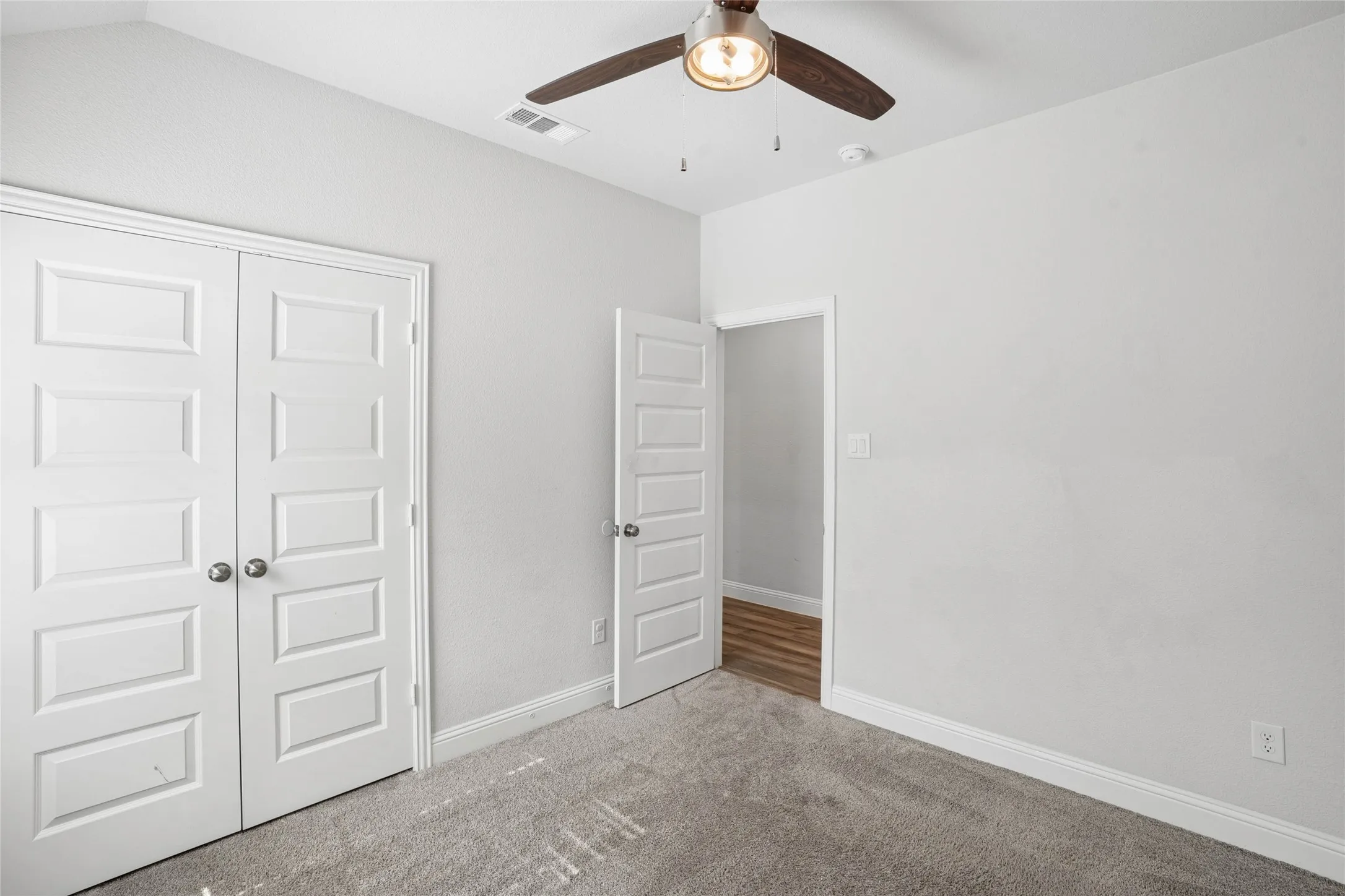 Carpeted room with light grey walls