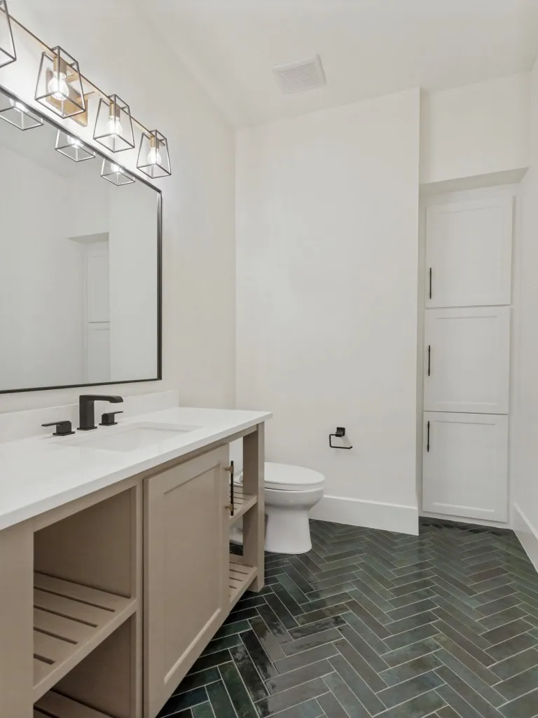 Bathroom featuring a single vanity with a light countertop, black fixtures, and a rectangular mirror