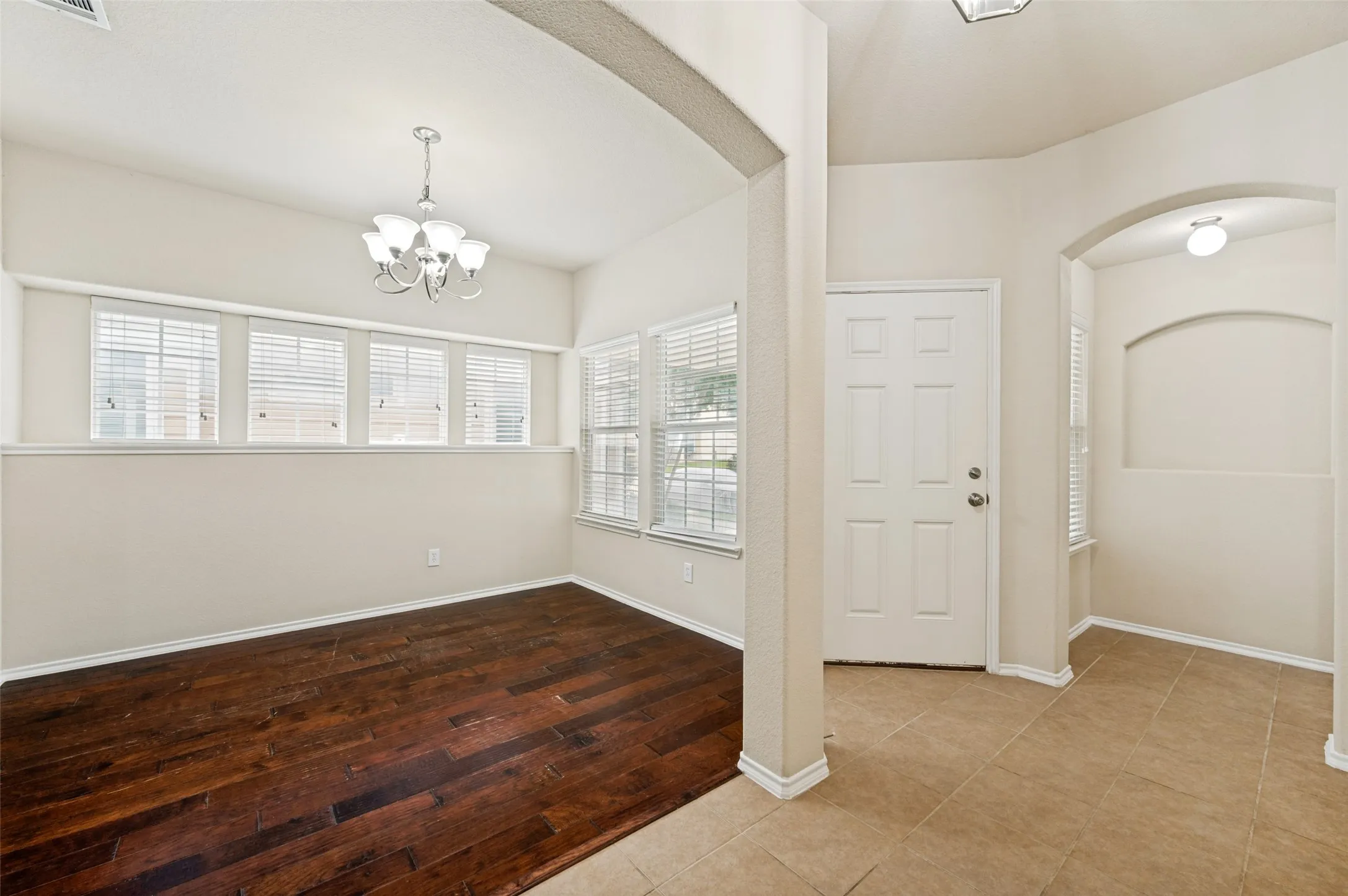 Entryway featuring a paneled door, ceramic tile flooring, and an arched niche