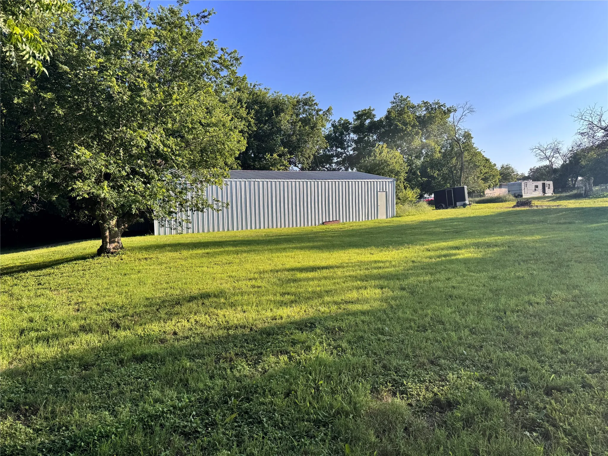 Expansive grassy yard with mature trees