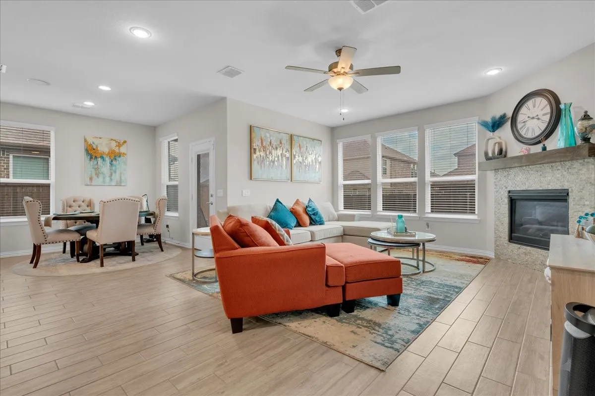 Open-concept living area featuring light wood-finish flooring, recessed lighting, and a ceiling fan