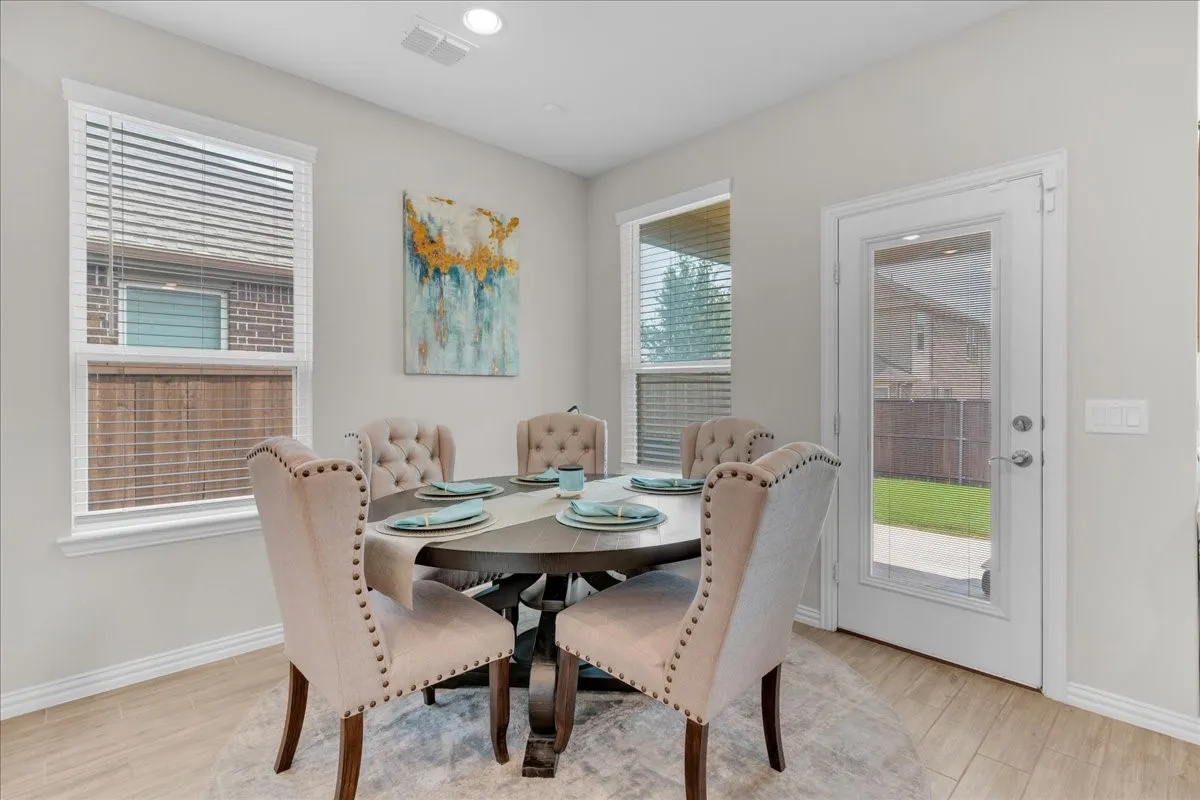 Dining area featuring light wood-finish flooring, recessed lighting, and a white paneled door with a full-light insert