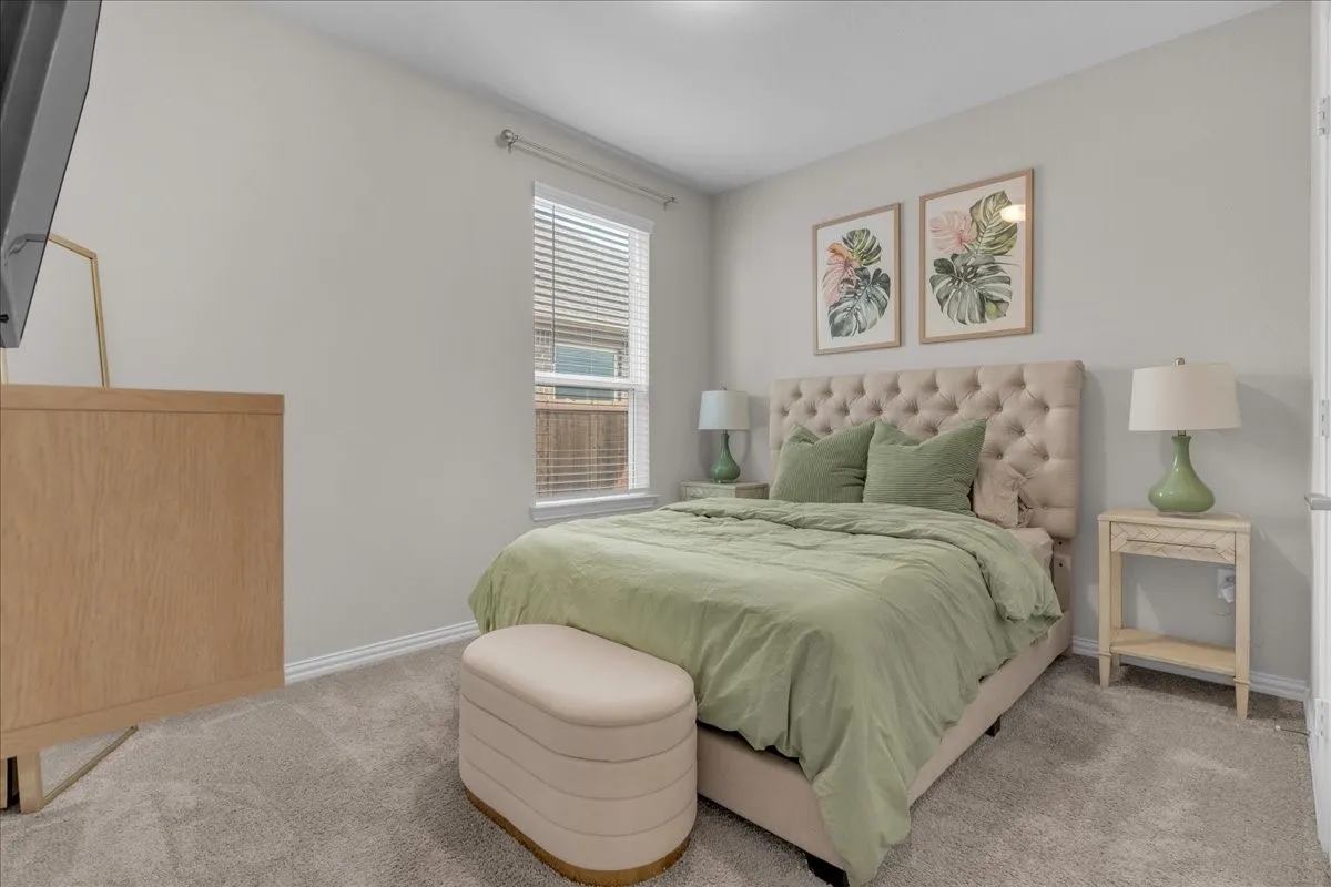 Carpeted bedroom with neutral wall tones and a window with horizontal blinds