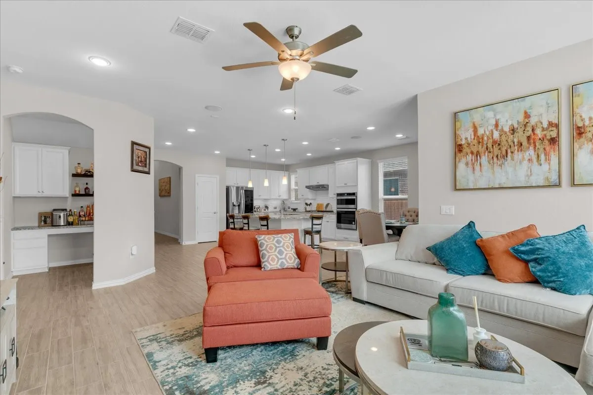 Open-concept living area featuring wood-finish flooring, recessed lighting, and a ceiling fan