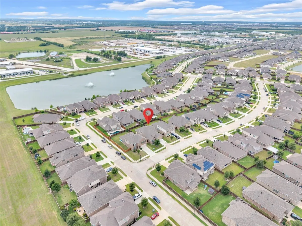 Aerial perspective showcasing a residential development with a prominent community lake featuring fountains