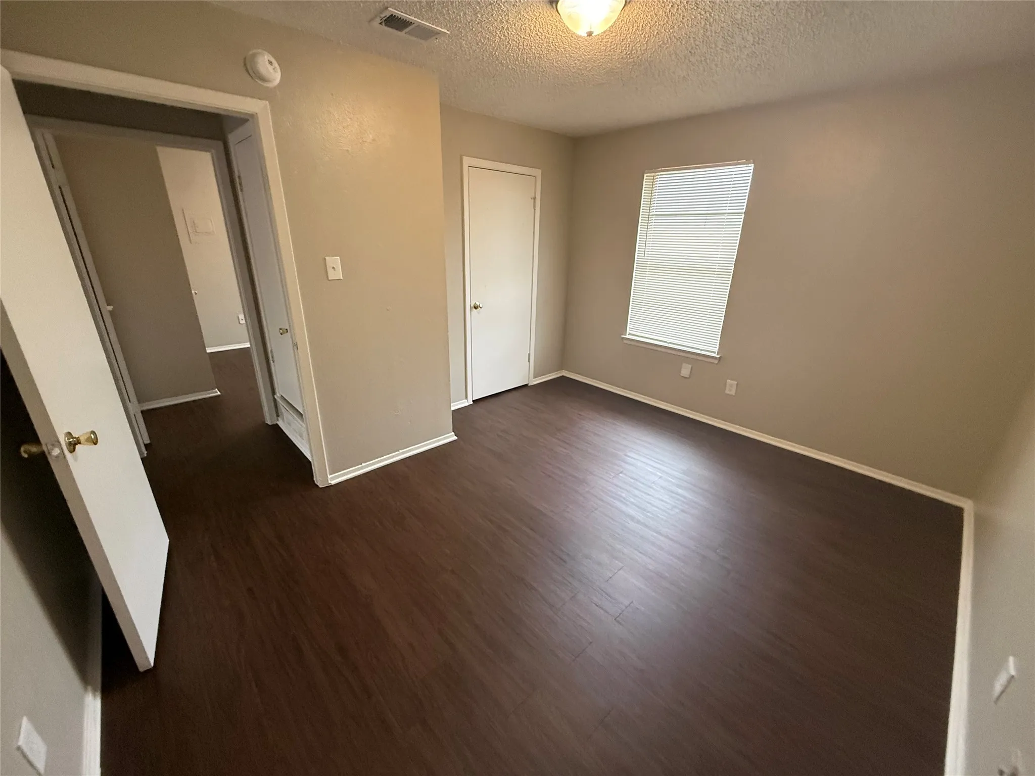 Room featuring wood-finish flooring, neutral wall tones, and white trim