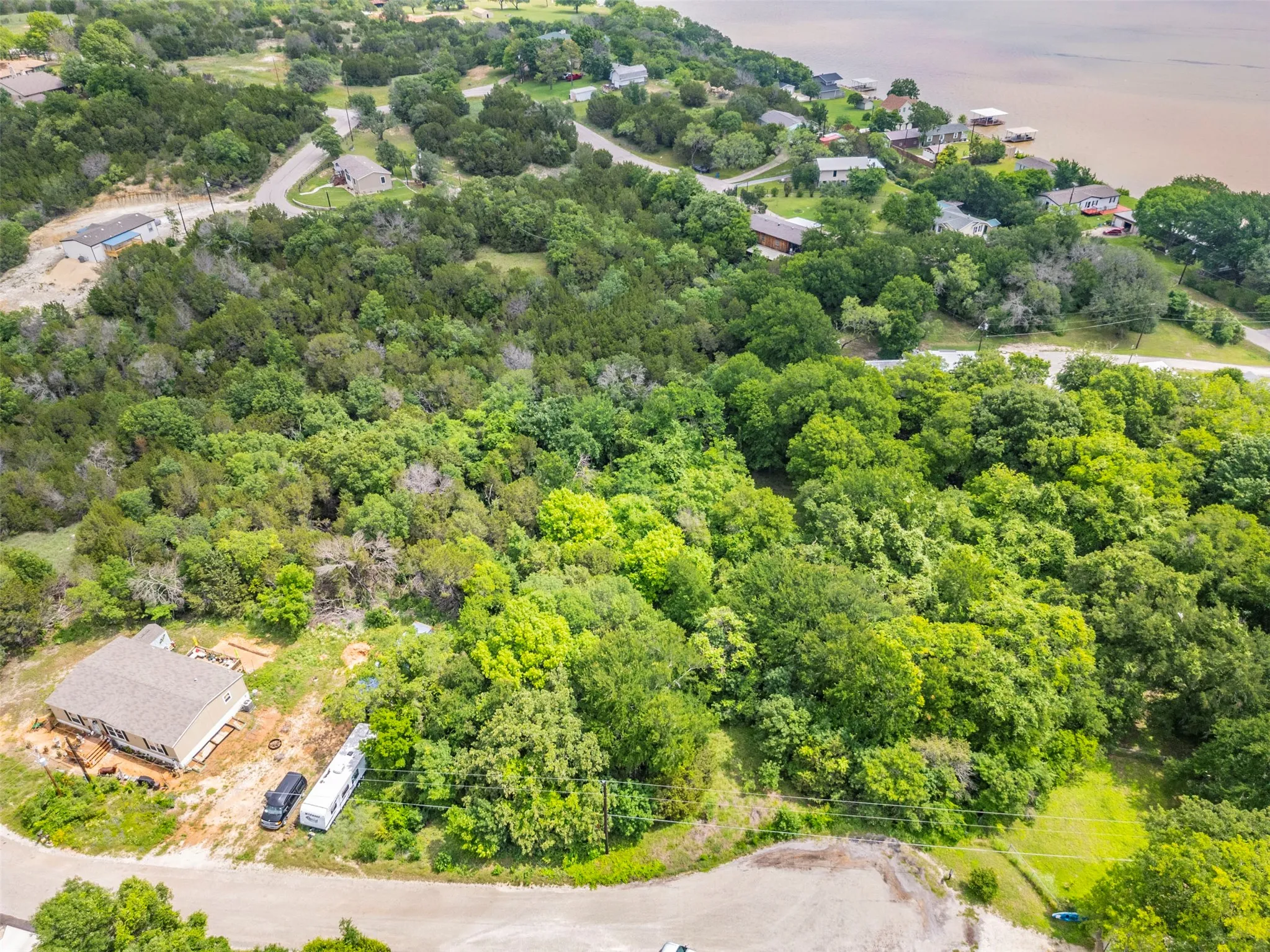 Expansive wooded property featuring mature trees and a gently winding paved road