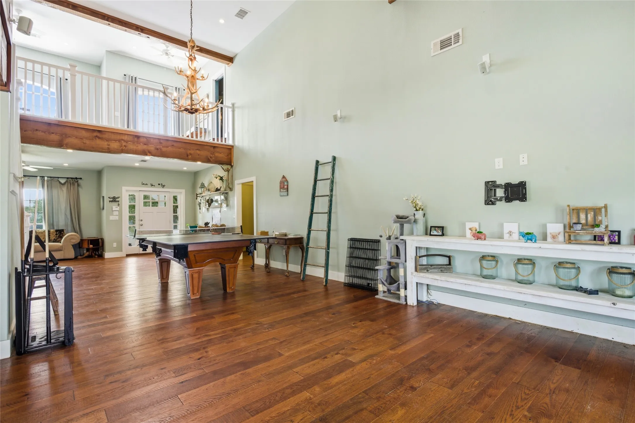 Located in the center of this big room, a game area is set up - pool or ping pong is available.  The loft overhead and the antler light  feature add charm to the area.