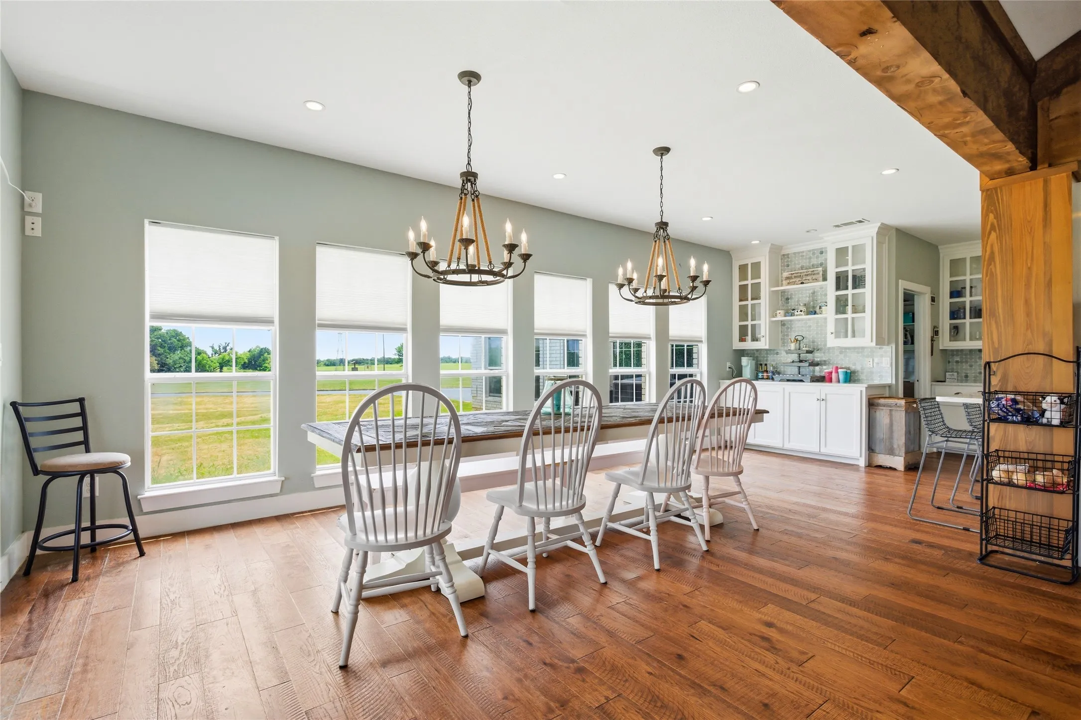 Moving to the right side of the home, a large dining area with landscape views provides for ample room to dine, visit, and enjoy each other's company.  A coffee bar within the custom built kitchen cabinet also highlights this area.