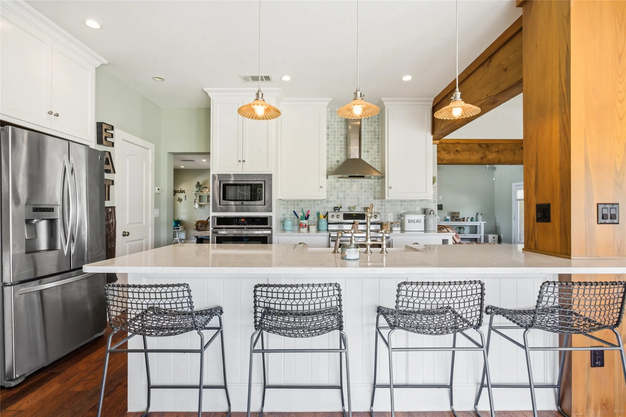 The layout of the kitchen in the heart of the home pulls people to this area.  Through the open door on the left, you can see into the front foyer and there is access there to the other main floor bedroom.