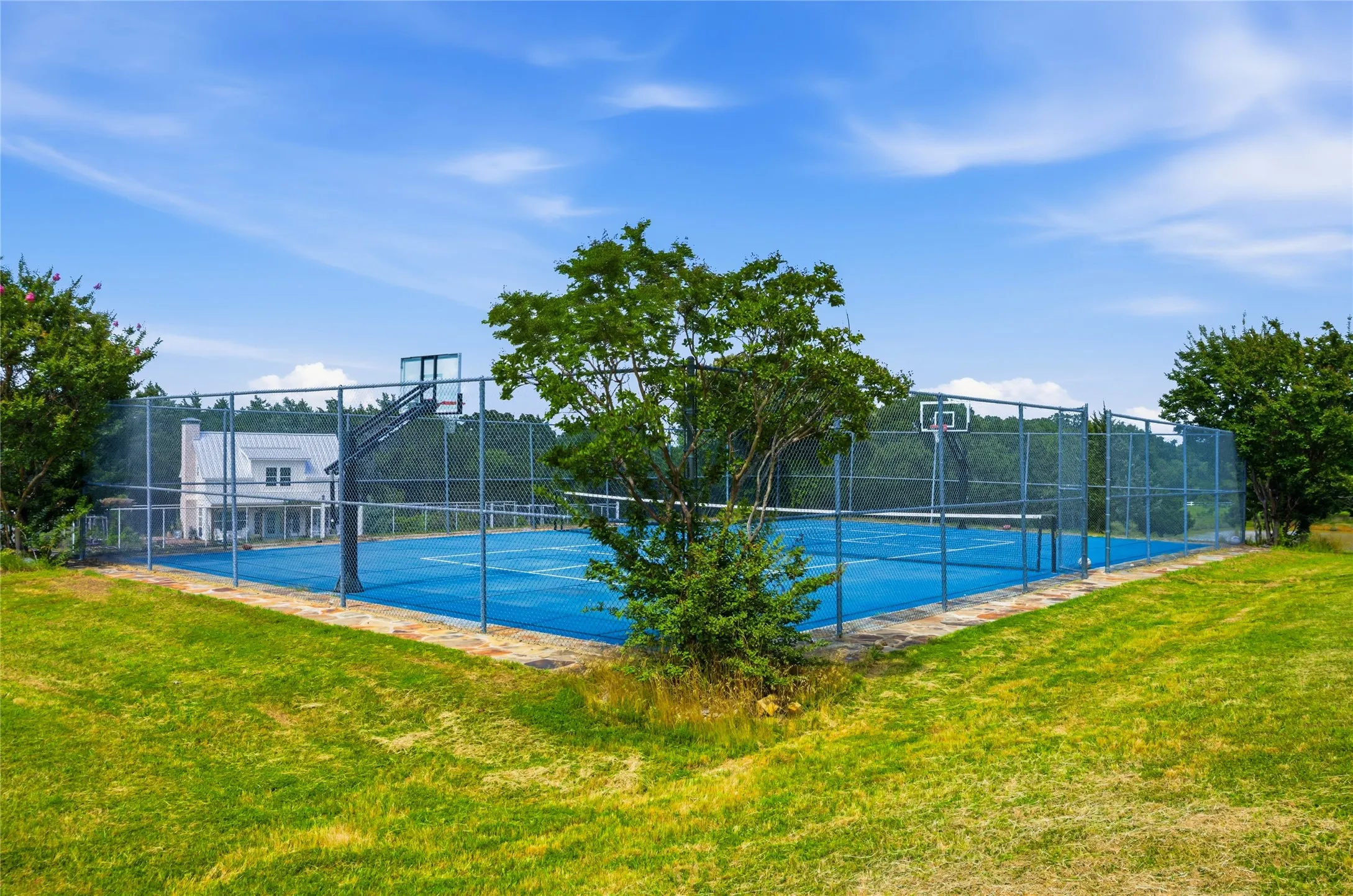 What a fun addition!  This fenced pickleball area could be marked for tennis as well.  Family and guests can all have some fun here!