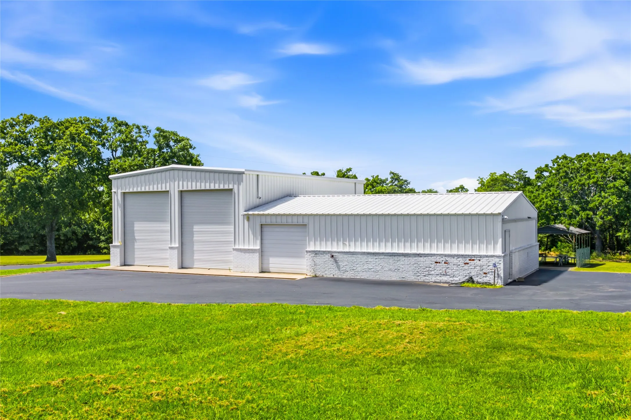 Besides the attached 2 car garage at the house, there is a large garage that features a 2-car RV garage and 2 other single car garages.  This building  has plenty of shop space as well.  Not shown in this picture is another carport in behind and to the left of this building.
