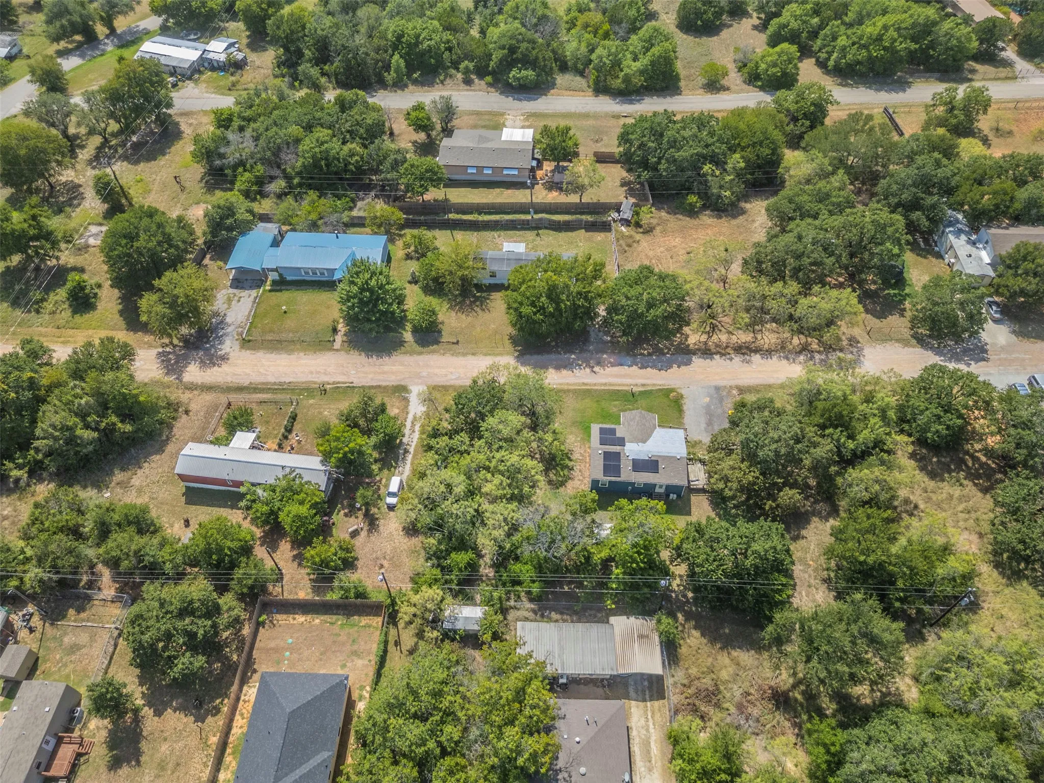 Aerial perspective showcasing multiple residential properties and verdant tree coverage