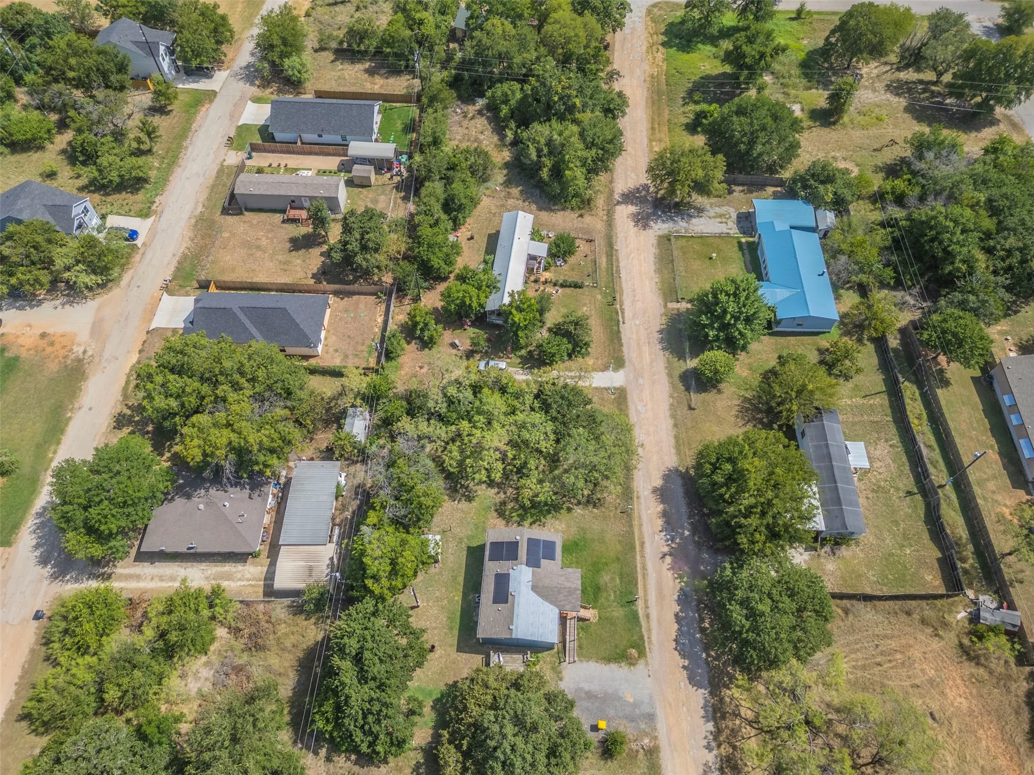 Aerial perspective showcasing multiple properties along unpaved roads