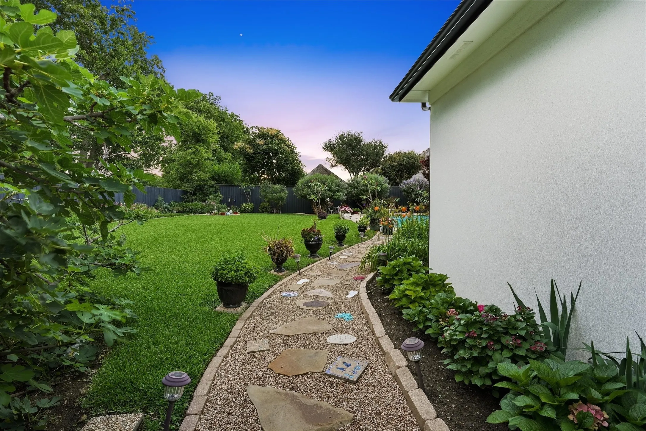 Well manicured path from side of home to back yard pool.