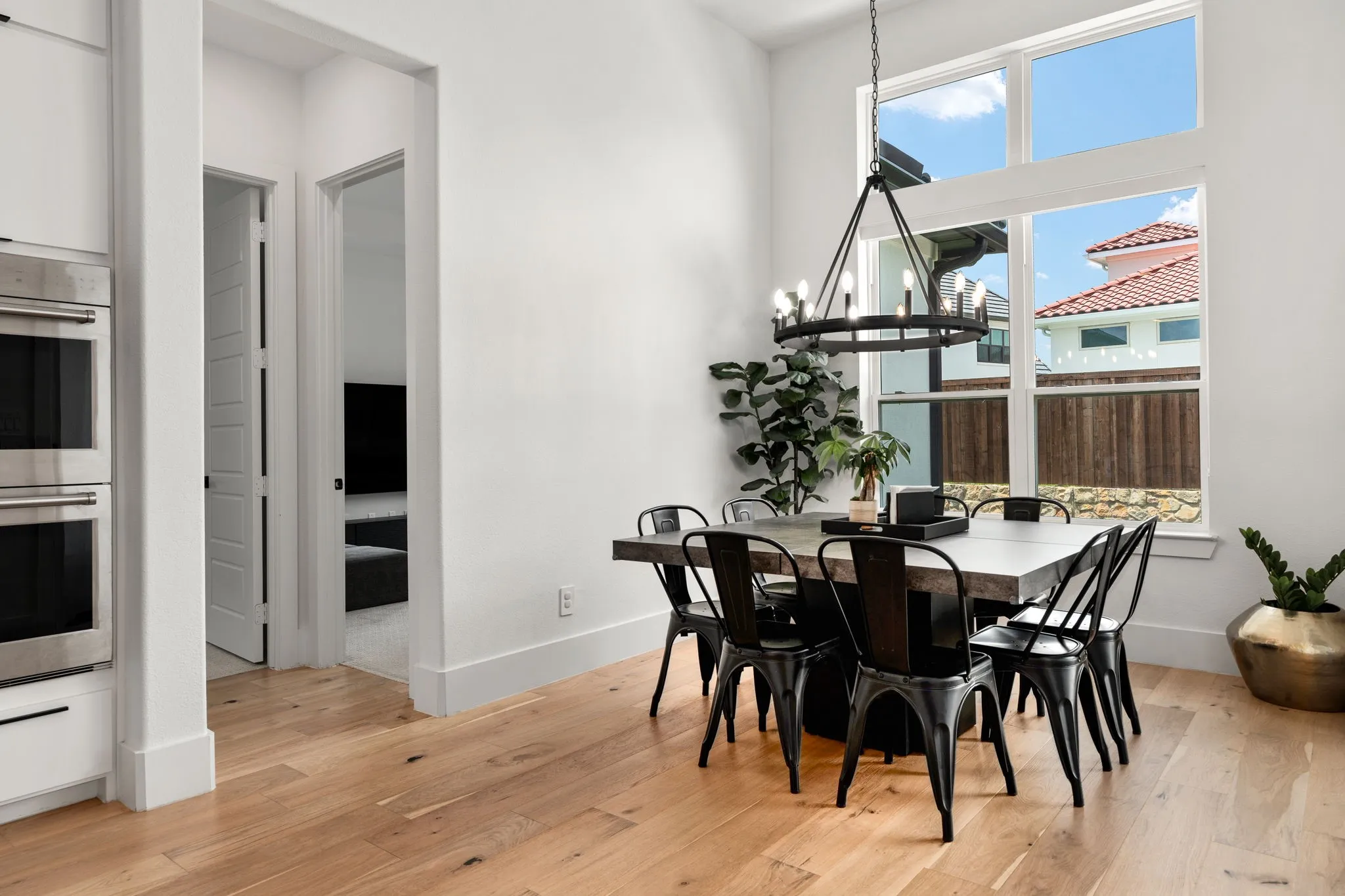 Dining area featuring high ceilings, wood-finish flooring, and a large window arrangement