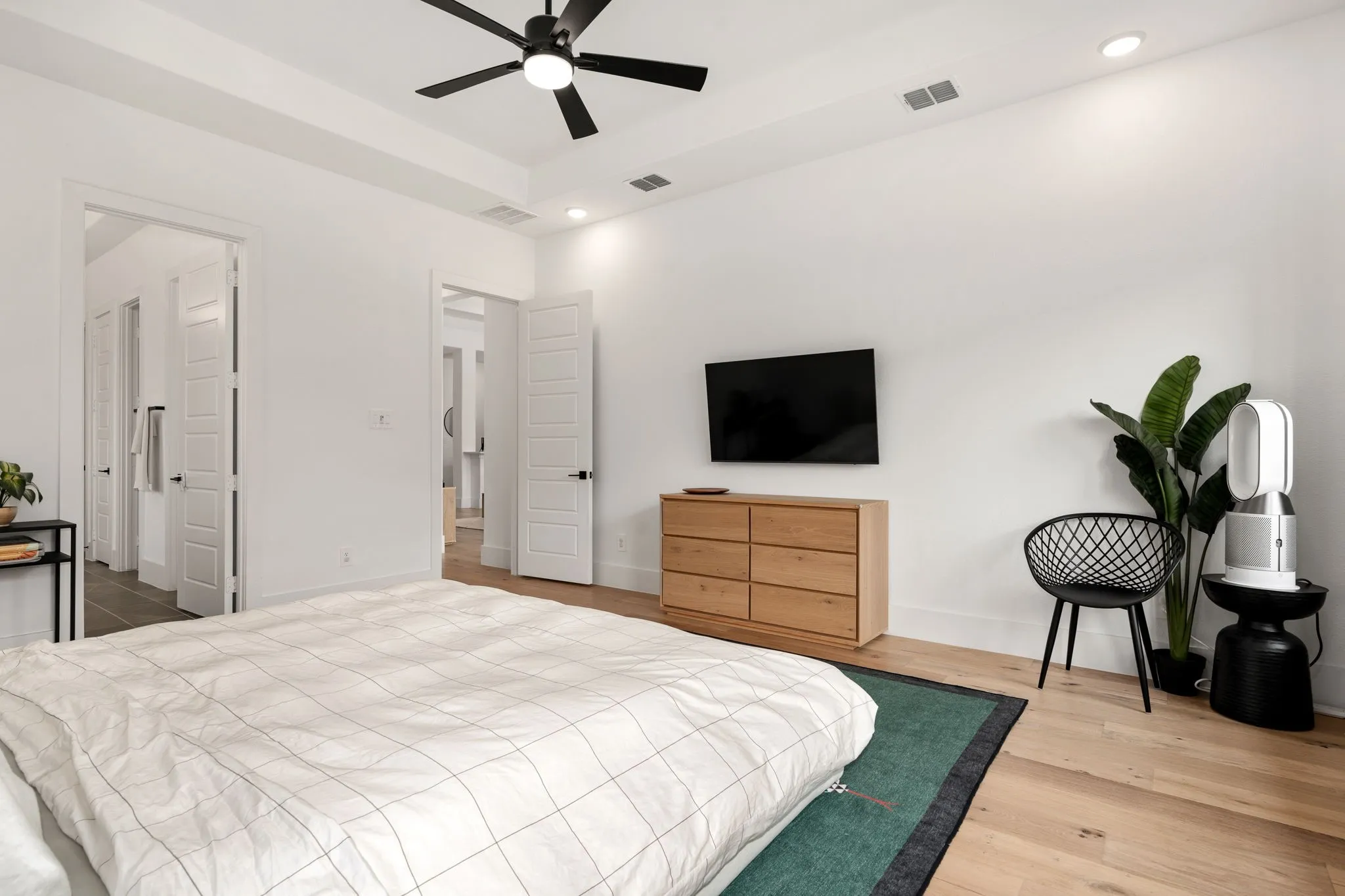 Tray ceiling with recessed lighting and a black ceiling fan