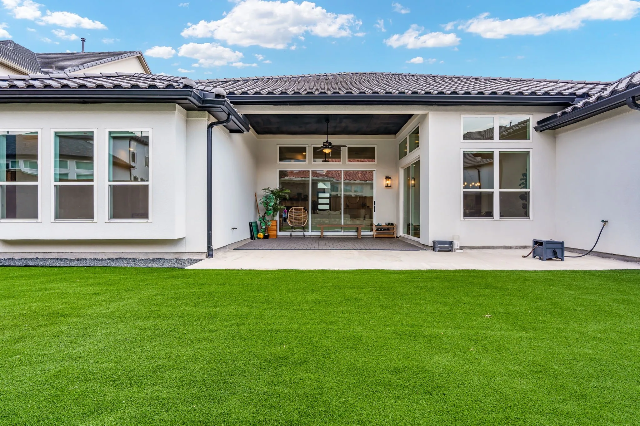 Expansive artificial turf lawn with a large covered patio